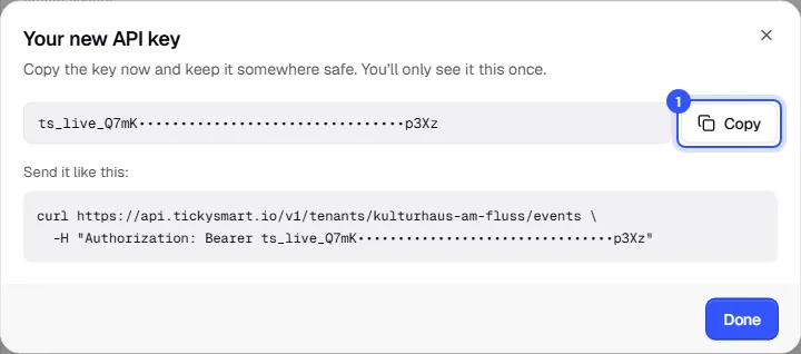 Your new API key dialog with the hidden key, the Copy button and an example request with curl